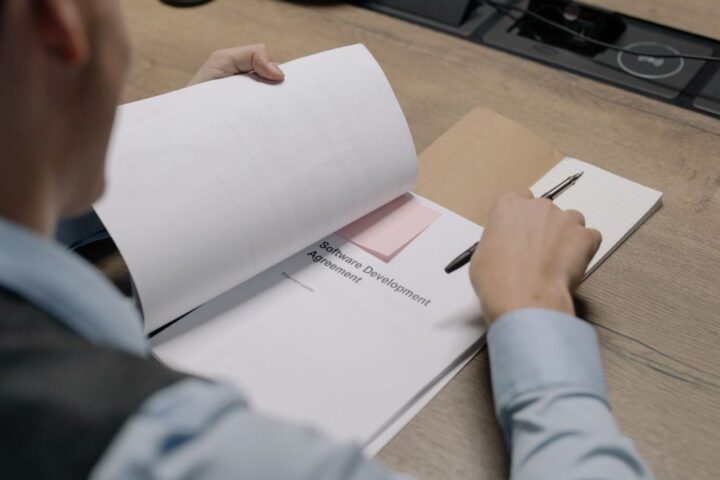机の上で書類を広げて内容を確認しているイメージ