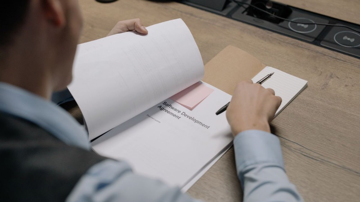 机の上で書類を広げて内容を確認しているイメージ