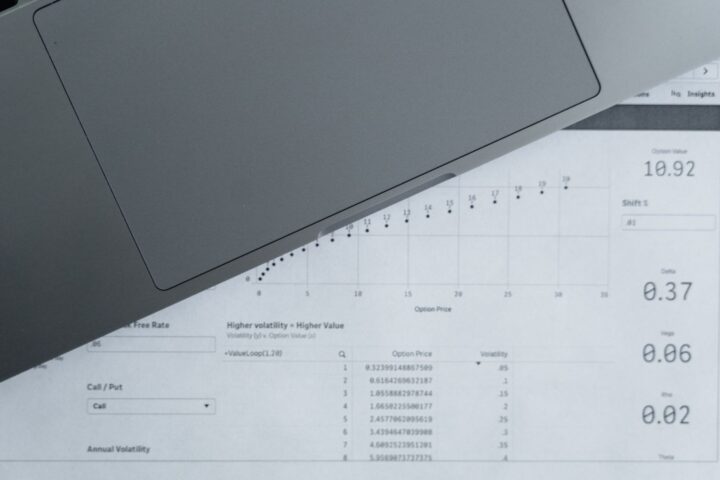 ノートパソコンと数字が並んだ資料を上から見たところ。収支を自分で計算し直すイメージ