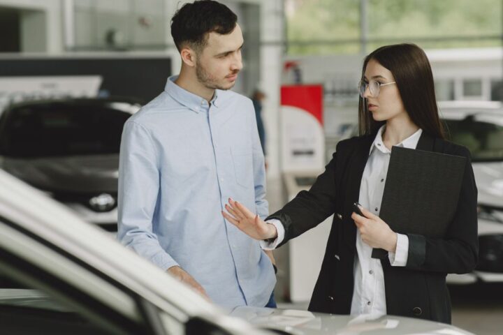 販売店で車を前に話をしているイメージ