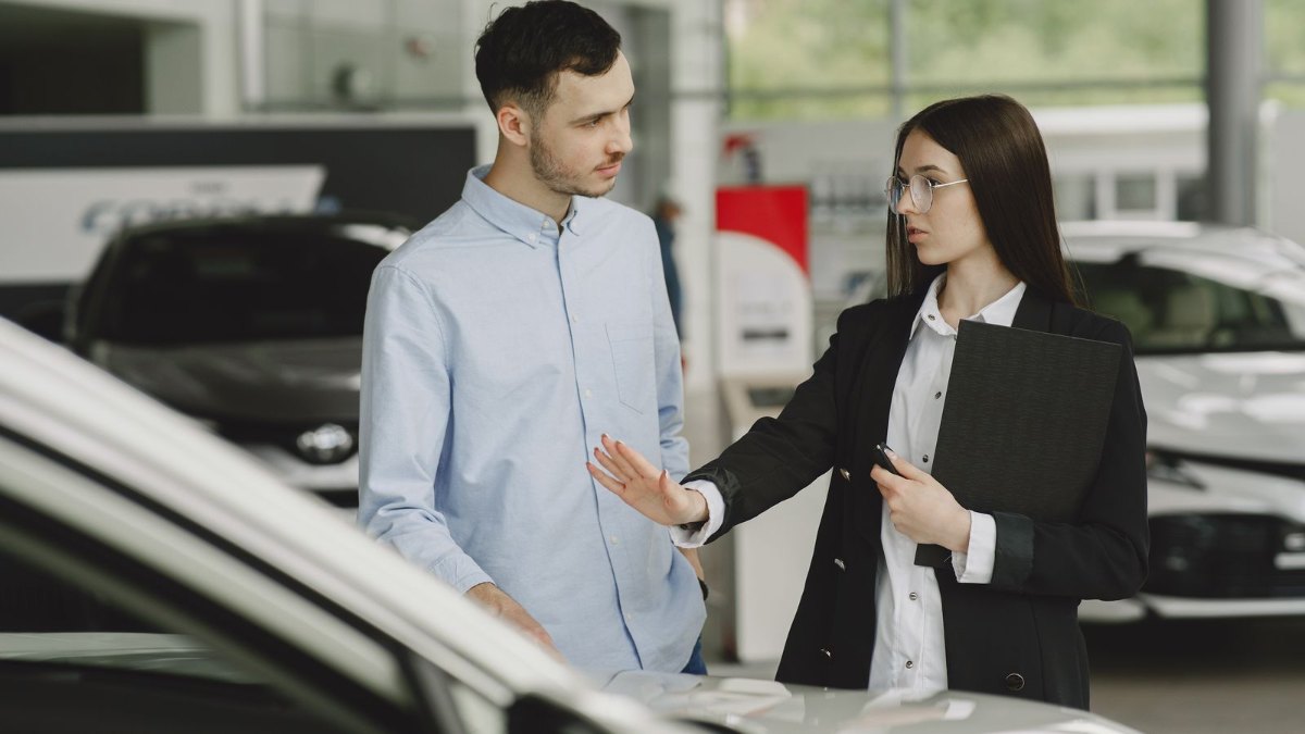 販売店で車を前に話をしているイメージ